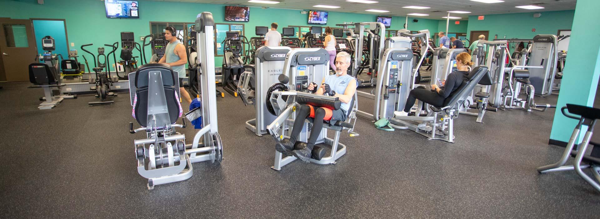 Wellness fitness center with people on workout machines at the Outer Banks Family YMCA