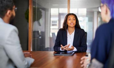 Teen girl pitching idea for business at table with two people