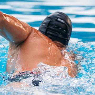 Man swims away in a swimming pool