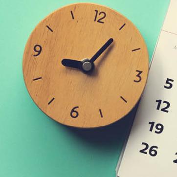 Green background with wooden click and paper calendar displayed at an angle