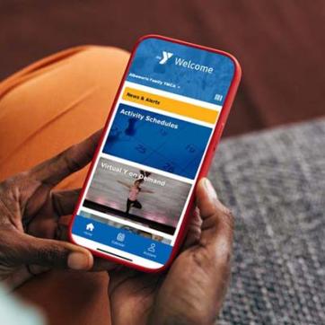 Hands holding a mobile phone with the YMCA Pulse app on the screen