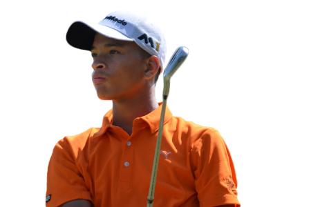 Teenage golfer looking into the distance with club over shoulder