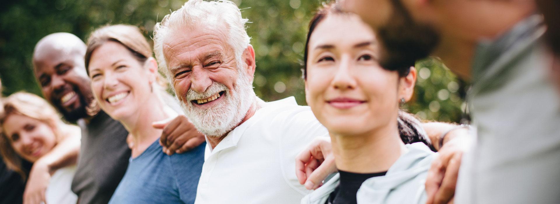 Community members with arms around each other's shoulders in a line